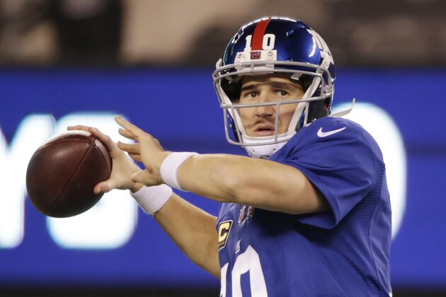 New York Giants quarterback Eli Manning (10) warms up before playing against the Dallas Cowboys in an NFL football game, Sunday, Nov. 23, 2014, in East Rutherford, N.J. (AP Photo/Julio Cortez)