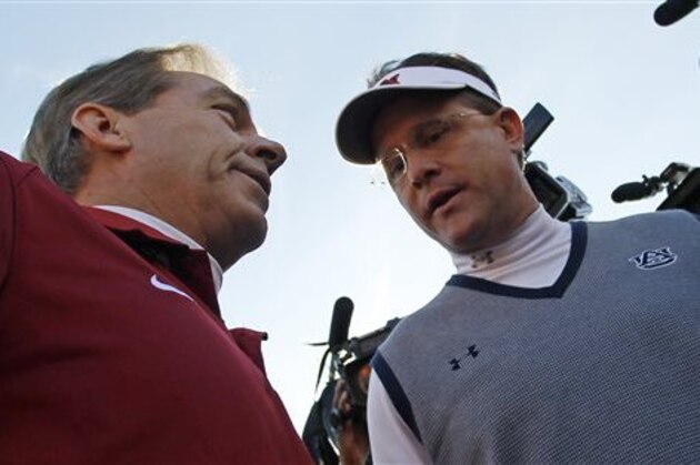 FILE - In this Nov. 30, 2013, file photo, Alabama head coach Nick Saban, left, talks with Auburn head coach Gus Malzahn prior to the start of an NCAA college football game in Auburn, Ala. Saban has had Alabama collecting five-star recruits and national titles with such relentless regularity that some pundits have wondered if he might be college football's best coach ever. Then comes Malzahn, a former Arkansas high school coach who leads the sixth-ranked Tigers to the Southeastern Conference title and national championship game in his first season. (AP Photo/Butch Dill, File)