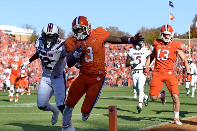 Clemson's Artavis Scott runs in for a touchdown while pursued by South Carolina's Brison Williams during the second half of an NCAA college football game in Clemson, S.C.,  Saturday, Nov. 29, 2014. (AP Photo/Richard Shiro)