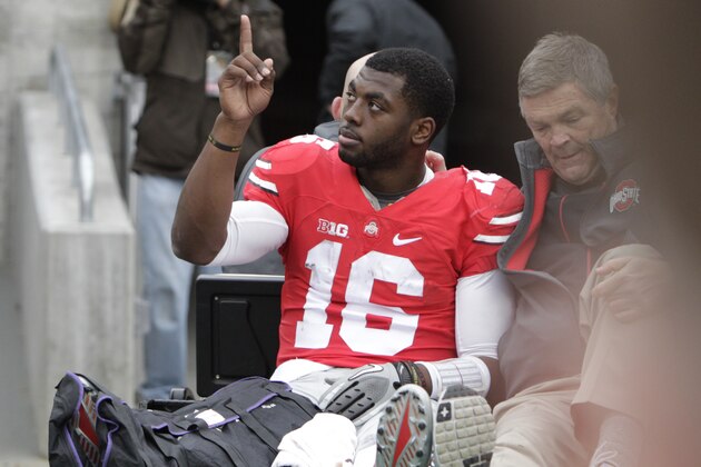 Ohio State quarterback J.T. Barrett acknowledges fans as he is driven from the field after an injury in the fourth quarter of an NCAA college football game Saturday, Nov. 29, 2014, in Columbus, Ohio. Ohio State beat Michigan 42-28. (AP Photo/Jay LaPrete)