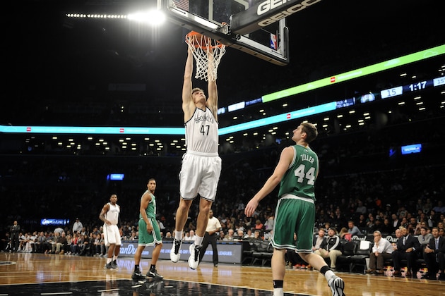 Boston Celtics center Tyler Zeller (44) watches Brooklyn Nets forward Andrei Kirilenko (47) dunk a basket during the first half of a preseason NBA basketball game on Sunday, Oct. 19, 2014 at Barclays Center in New York. (AP Photo/Kathy Kmonicek)