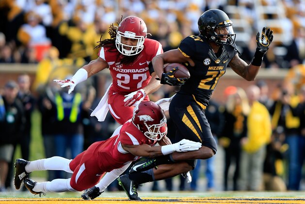 COLUMBIA, MO - NOVEMBER 28:  Receiver Bud Sasser #21 of the Missouri Tigers is tackled by Jared Collins #29 and Alan Turner #27 of the Arkansas Razorbacks after making a catch during the game at Faurot Field/Memorial Stadium on November 28, 2014 in Columbia, Missouri.  (Photo by Jamie Squire/Getty Images)