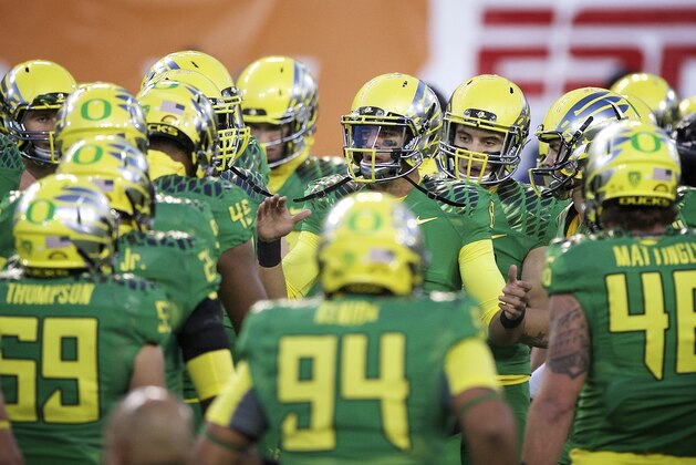 Oregon quarterback Marcus Mariota (8) leads the Ducks through warm up drills before an NCAA college football game against Oregon State in Corvallis, Or., Saturday, Nov. 15, 2014. (AP Photo/Troy Wayrynen)