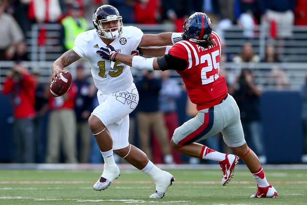 OXFORD, MS - NOVEMBER 29:  Cody Prewitt #25 of the Mississippi Rebels tries to tackle Dak Prescott #15 of the Mississippi State Bulldogs during their game at Vaught-Hemingway Stadium on November 29, 2014 in Oxford, Mississippi.  (Photo by Streeter Lecka/Getty Images)