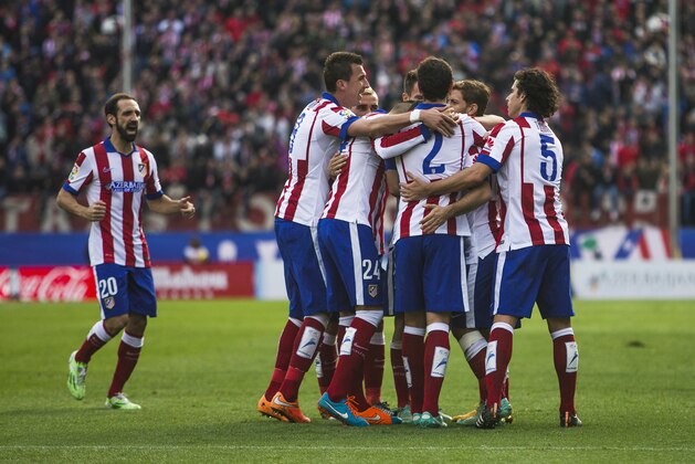 Atletico's Arda Turan celebrates his goal with team mates during a Spanish La Liga soccer match between Atletico and Deportivo Coruna at the Vicente Calderon stadium in Madrid, Spain, Sunday, Nov. 30, 2014. (AP Photo/Andres Kudacki)