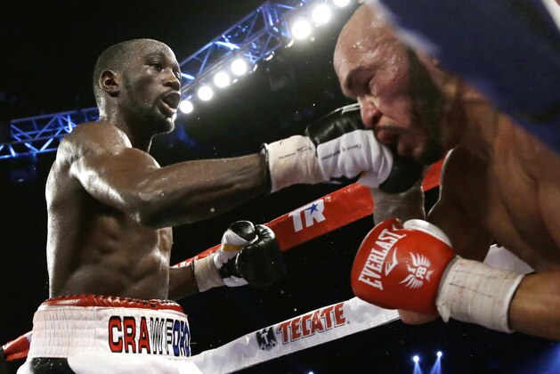 Terence Crawford, left, lands a punch on Raymundo Beltran during a WBO lightweight title boxing bout in Omaha, Neb., early Sunday, Nov. 30, 2014. Crawford defended his title. (AP Photo/Nati Harnik)