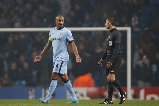 Manchester City's Vincent Kompany speaks to referee Tasos Sidiropoulos during the Champions League group E soccer match between Manchester City and CSKA Moscow, at the Etihad Stadium, in Manchester, England, Wednesday, Nov. 5, 2014. (AP Photo/Jon Super)