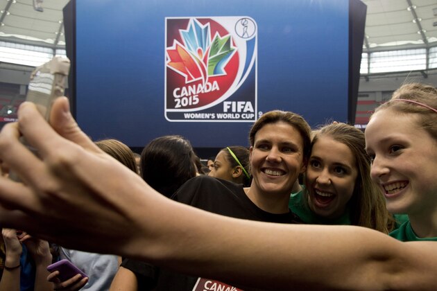 Team Canada's Christine Sinclair takes a photo with young soccer fans as FIFA unveils the official emblem for the 2015 Women's World Cup soccer tournament during a ceremony in downtown Vancouver,  British Columbia Friday, Dec. 14, 2012. (AP Photo/The Canadian Press, Jonathan Hayward)