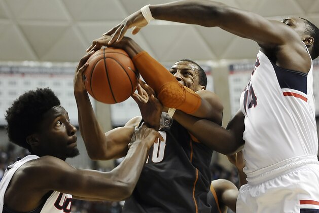 Texas’ Jonathan Holmes, center, gets tangled with Connecticut’s Daniel Hamilton, left, and Connecticut’s Rakim Lubin, right, during the first half of an NCAA college basketball game, Sunday, Nov. 30, 2014, in Storrs, Conn. (AP Photo/Jessica Hill)