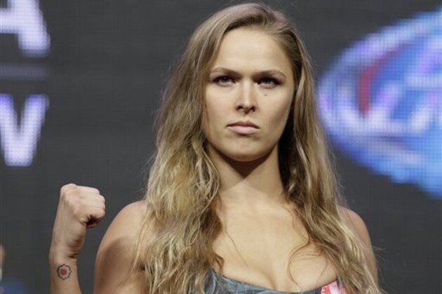 Ronda Rousey poses for photographers during a weigh-in for the UFC 175 mixed martial arts event at the Mandalay Bay, Friday, July 4, 2014, in Las Vegas. Rousey is scheduled to fight Alexis Davis in a women's bantamweight title fight on Saturday in Las Vegas. (AP Photo/John Locher)
