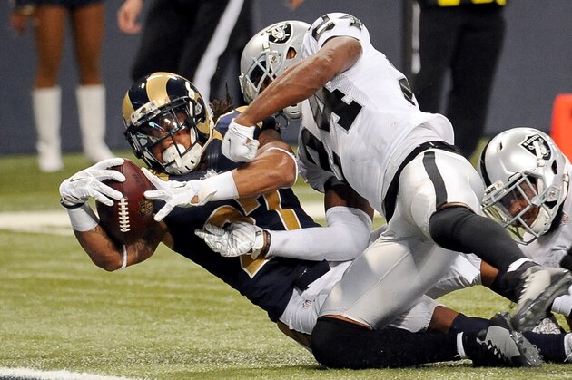St. Louis Rams running back Tre Mason, left, scores on an 8-yard run as Oakland Raiders free safety Charles Woodson defends during the fourth quarter of an NFL football game Sunday, Nov. 30, 2014, in St. Louis. (AP Photo/L.G. Patterson)