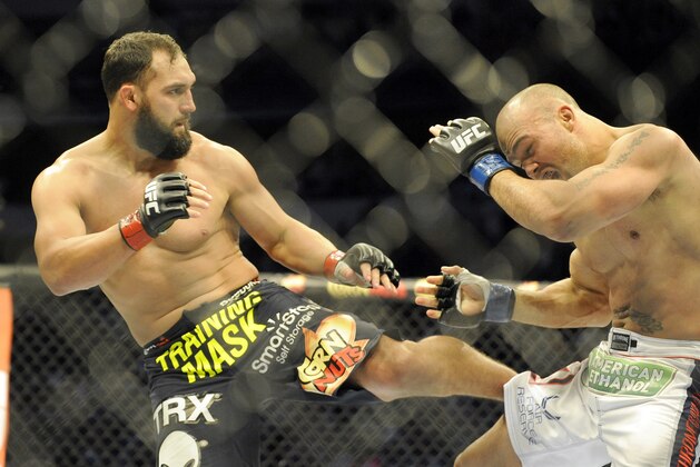 Johny Hendricks, left, lands a kick on  Robbie Lawler during a UFC 171 mixed martial arts welterweight title bout, Saturday, March 15, 2014, in Dallas. Hendricks won by decision. (AP Photo/Matt Strasen)