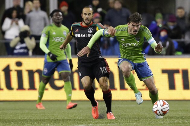 Los Angeles Galaxy midfielder Landon Donovan, center, challenges Seattle Sounders midfielder Brad Evans, right, in the first half of the second leg of the MLS western conference final soccer match, Sunday, Nov. 30, 2014, in Seattle. (AP Photo/Ted S. Warren)
