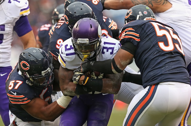CHICAGO, IL - NOVEMBER 16:  Jerick McKinnon #31 of the Minnesota Vikings is stopped by (L-R) Jon Bostic #57, Jeremiah Ratliff #90 and  Lance Briggs #55 of the Chicago Bears at Soldier Field on October 19, 2014 in Chicago, Illinois. The Bears defeated the Vikings 21-13.  (Photo by Jonathan Daniel/Getty Images)