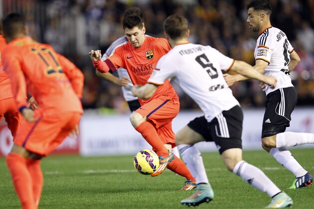 Barcelona's Lionel Messi, from Argentina, drives the ball past Valencia's Mustafi  during a Spanish La Liga soccer match at the Mestalla stadium in Valencia, Spain, on Sunday, Nov. 30, 2014.(AP Photo/Alberto Saiz)
