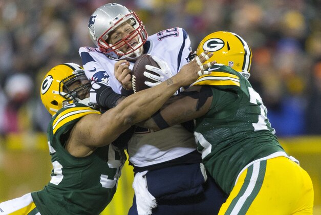 Nov 30, 2014; Green Bay, WI, USA; New England Patriots quarterback Tom Brady (12) is sacked by Green Bay Packers defensive end Mike Neal (96) and defensive end Mike Daniels (76) during the fourth quarter at Lambeau Field.  Green Bay won 26-21.  Mandatory Credit: Jeff Hanisch-USA TODAY Sports