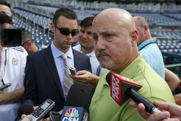 FILE - In this July 31, 2014 file photo, Washington Nationals general manager Mike Rizzo pauses while speaking to reporters before a baseball game against the Philadelphia Phillies at Nationals Park in Washington. Two years after famously being shut down by the Washington Nationals to protect his elbow, Stephen Strasburg finally will make his postseason debut this week for the NL East champions.