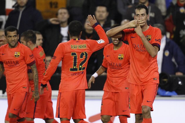 Barcelona's Sergio Busquets, right, celebrates after scoring against Valencia during a Spanish La Liga soccer match at the Mestalla stadium in Valencia, Spain, on Sunday, Nov. 30, 2014.(AP Photo/Alberto Saiz)