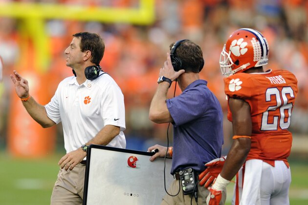Clemson head coach Dabo Swinney, left, calls out a play to his team while defensive coordinator Brent Venables, center, and Garry Peters watch during the second half of an NCAA college football game against Boston College, Saturday, Oct. 12, 2013, at Memorial Stadium in Clemson, S.C. Clemson won 24-14. (AP Photo/ Richard Shiro)