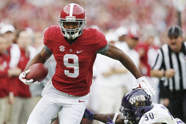 Alabama wide receiver Amari Cooper (9) avoids the tackle from Western Carolina defensive back A.J. McKoy (30) during the first half of an NCAA college football game, Saturday, Nov. 22, 2014, in Tuscaloosa, Ala. Cooper limped off the field after an injury on the play. (AP Photo/Brynn Anderson)
