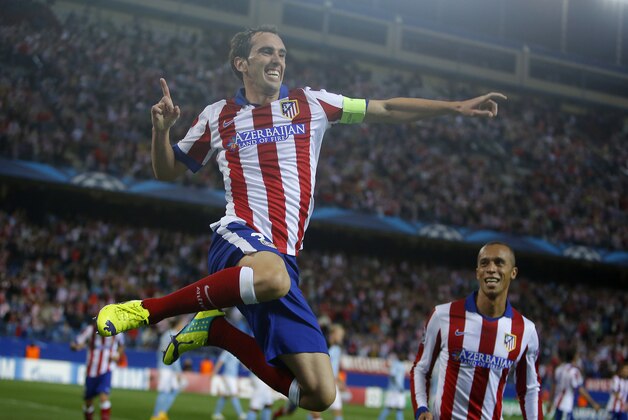 Atletico's Diego Godin, right, celebrates with his teammate Miranda after scoring during the Group A Champions League soccer match between Atletico de Madrid and Malmo at the Vicente Calderon stadium in Madrid, Spain, Wednesday, Oct. 22, 2014. (AP Photo/Andres Kudacki)
