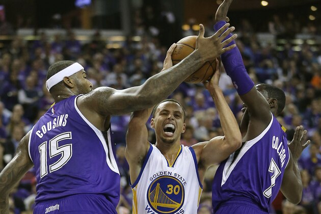 Golden State Warriors guard Stephen Curry, center, tries to drive between Sacramento Kings' DeMarcus Cousins, left, Darren Collison during the first half of an NBA basketball game in Sacramento, Calif., Wednesday, Oct. 29 2014. (AP Photo/Rich Pedroncelli)