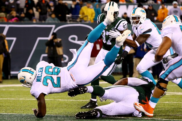 EAST RUTHERFORD, NJ - DECEMBER 01:  Lamar Miller #26 of the Miami Dolphins scores a 4 yard touchdown in the fourth quarter to tie the game against the New York Jets at MetLife Stadium on December 1, 2014 in East Rutherford, New Jersey.  (Photo by Al Bello/Getty Images)