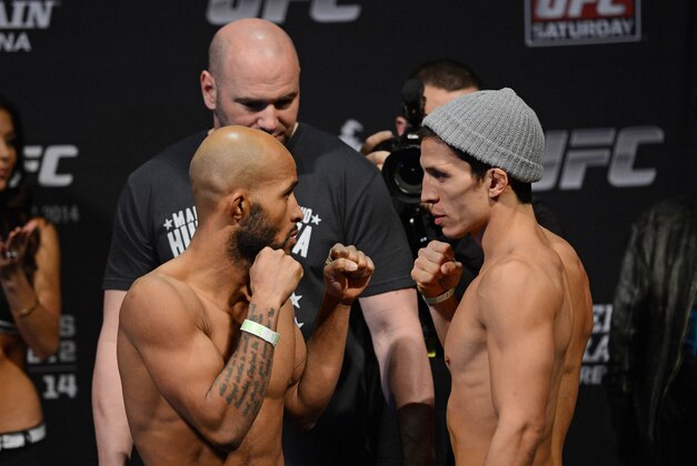 December 13, 2013; Sacramento, CA, USA; UFC flyweight championship fighters Demetrious Johnson (left) and Joseph Benavidez (right) face-off in front of UFC president Dana White (center) in the official weigh-in for UFC on FOX 9 at Sleep Train Arena. Mandatory Credit: Kyle Terada-USA TODAY Sports