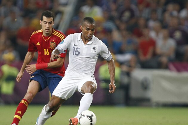 France’s Florent Malouda, right and Spain’s Sergio Busquets fight for the ball during the Euro 2012 soccer championship quarterfinal match between Spain and France in Donetsk, Ukraine, Saturday, June 23, 2012. (AP Photo/Darko Vojinovic)