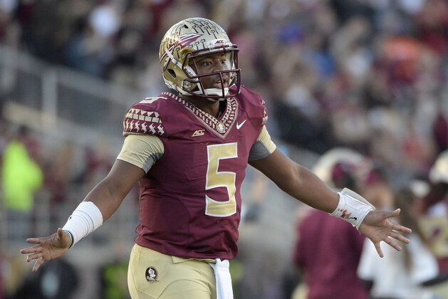 Florida State quarterback Jameis Winston (5) walks on the field to congratulate teammates after a successful extra-point kick during the first half of an NCAA college football game against Florida in Tallahassee, Fla., Saturday, Nov. 29, 2014.(AP Photo/Phelan M. Ebenhack)