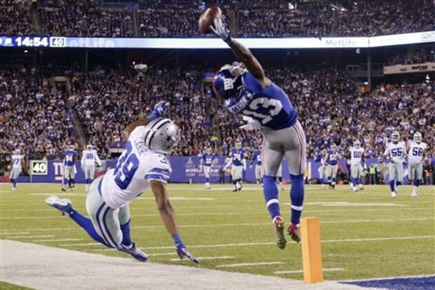 FILE - In this Nov. 23, 2014, file photo, New York Giants wide receiver Odell Beckham Jr. (13) makes a one-handed catch for a touchdown against Dallas Cowboys cornerback Brandon Carr (39) in the second quarter of an NFL football game in East Rutherford, N.J. The one-handed catch by Odell Beckham Jr. that became the most talked-about play from Sunday did more than just boost his standing with the New York Giants, it paid off a routine growing popular among many skill players of practicing the impractical, one-handed circus grab.  (AP Photo/Julio Cortez, FILE)
