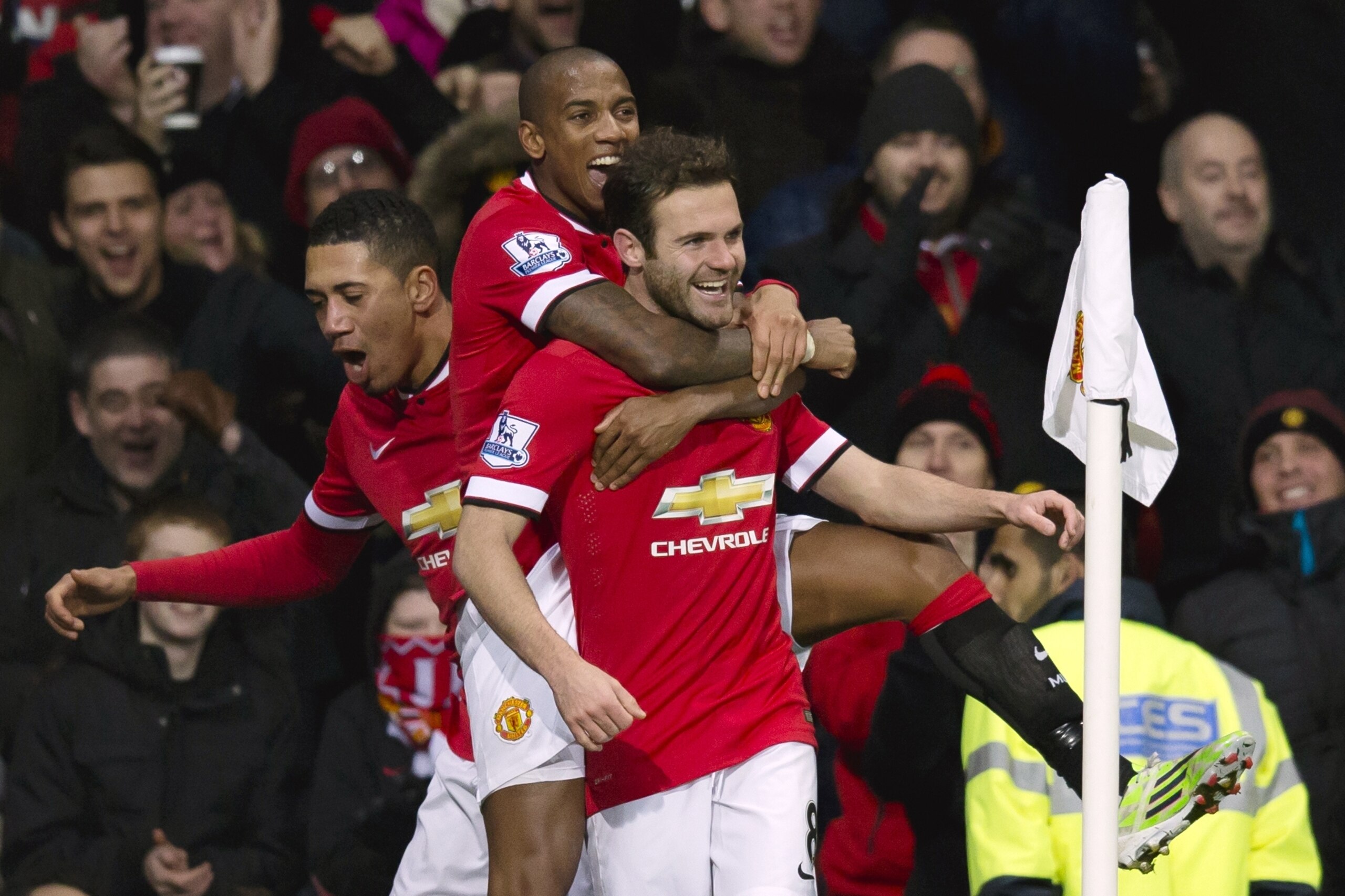 Manchester United's Juan Mata, center, celebrates scoring with teammates during the English Premier League soccer match between Manchester United and Stoke City at Old Trafford Stadium, Manchester, England, Tuesday Dec. 2, 2014. (AP Photo/Jon Super)
