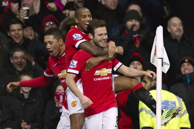 Manchester United's Juan Mata, center, celebrates scoring with teammates during the English Premier League soccer match between Manchester United and Stoke City at Old Trafford Stadium, Manchester, England, Tuesday Dec. 2, 2014. (AP Photo/Jon Super)