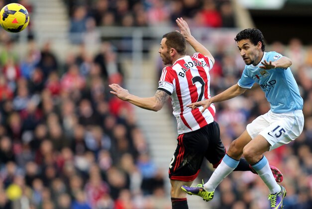 Manchester City's Jesus Navas, right, vies for the ball with Sunderland's  Phil Bardsley, left, during their English Premier League soccer match at the Stadium of Light, Sunderland, England, Sunday, Nov. 11, 2013. (AP Photo/Scott Heppell)