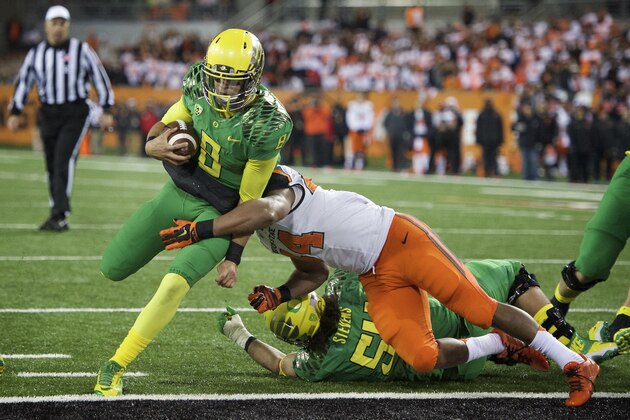 Oregon quarterback Marcus Mariota (8) scores a touchdown against Oregon State during the third quarter of an NCAA college football game in Corvallis, Or., Saturday, Nov. 15, 2014. (AP Photo/Troy Wayrynen)