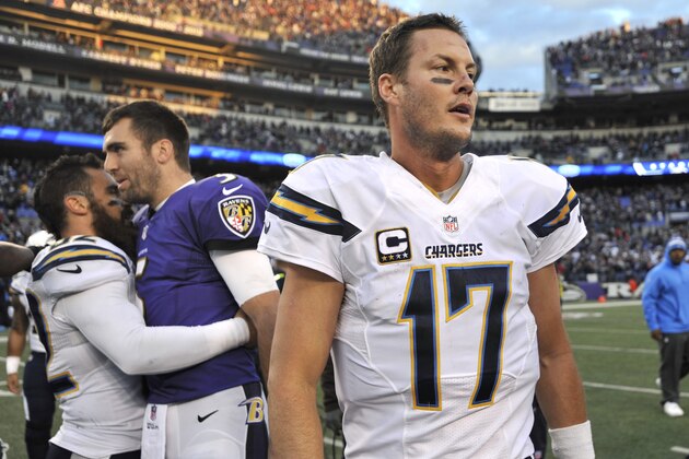 San Diego Chargers quarterback Philip Rivers (17) walks off the field as teammate Eric Weddle, back left, hugs Baltimore Ravens quarterback Joe Flacco after an NFL football game, Sunday, Nov. 30, 2014, in Baltimore. (AP Photo/Gail Burton)