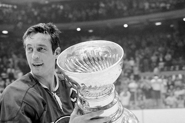 Montreal Canadiens team captain Jean Beliveau holds the Stanley Cup trophy after his team's 3-2 victory over the Chicago Black Hawks in the NHL playoff game in Chicago, Ill., Tuesday night, May 18, 1971.  (AP Photo)