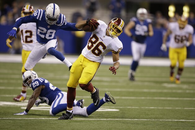 Washington Redskins tight end Jordan Reed, top, goes over Indianapolis Colts strong safety Mike Adams during the second half of an NFL football game Sunday, Nov. 30, 2014, in Indianapolis. (AP Photo/Darron Cummings)
