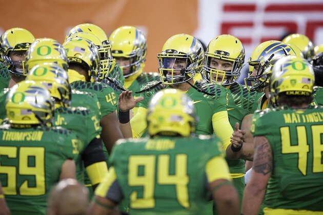 Oregon quarterback Marcus Mariota (8) leads the Ducks through warm up drills before an NCAA college football game against Oregon State in Corvallis, Or., Saturday, Nov. 15, 2014. (AP Photo/Troy Wayrynen)