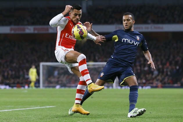 Arsenal's Alexis Sanchez, left, vies for the ball with Southampton's Ryan Bertrand during the English Premier League soccer match between Arsenal and Southampton at Emirates stadium in London, Wednesday, Dec. 3, 2014. (AP Photo/Kirsty Wigglesworth)