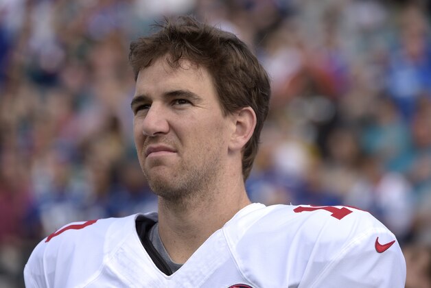 New York Giants quarterback Eli Manning (10) stands on the sideline for the singing of the national anthem prior to an NFL football game against the Jacksonville Jaguars in Jacksonville, Fla., Sunday, Nov. 30, 2014.(AP Photo/Phelan M. Ebenhack)