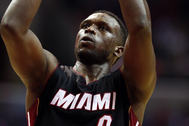 Miami Heat forward Luol Deng (9) shoots a free throw in the first half of an NBA basketball game against the Washington Wizards, Monday, Dec. 1, 2014, in Washington. (AP Photo/Alex Brandon)