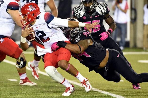 Arizona quarterback Anu Solomon (12) is sacked by  Oregon defensive lineman DeForest Buckner (44) and linebacker Torrodney Prevot (86) during the second quarter of the NCAA college football game at Autzen Stadium on Thursday, Oct. 2, 2014, in Eugene, Ore. Arizona won the game 31-24. (AP Photo/Steve Dykes)
