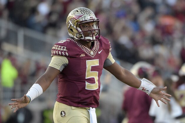 Florida State quarterback Jameis Winston (5) walks on the field to congratulate teammates after a successful extra-point kick during the first half of an NCAA college football game against Florida in Tallahassee, Fla., Saturday, Nov. 29, 2014.(AP Photo/Phelan M. Ebenhack)