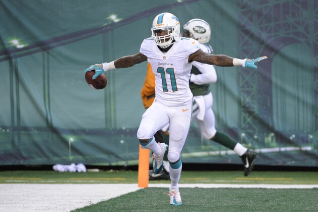 Miami Dolphins wide receiver Mike Wallace celebrates a touchdown reception on a pass from quarterback Ryan Tannehill during the second half of an NFL football game against the New York Jets, Sunday, Dec. 1, 2013, in East Rutherford, N.J. (AP Photo/Bill Kostroun)