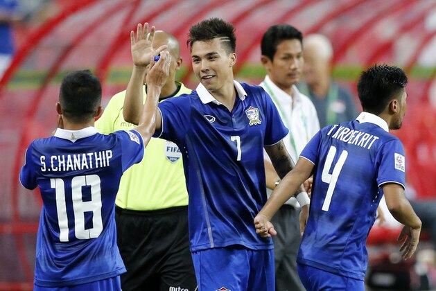 Thailand's Charyl Yannic Chappuis, centre, celebrates with teammates Chanathip Songkrasin, left, and Kroekrit Boonyong after scoring  a goal against Singapore during their AFF Suzuki Cup Group B soccer match in Singapore, Sunday, Nov. 23, 2014.(AP Photo/Wong Maye-E)