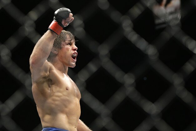 Urijah Faber celebrates after defeating Alex Caceres in their bantamweight mixed martial arts bout at UFC 175 on Saturday, July 5, 2014, in Las Vegas. (AP Photo/John Locher)