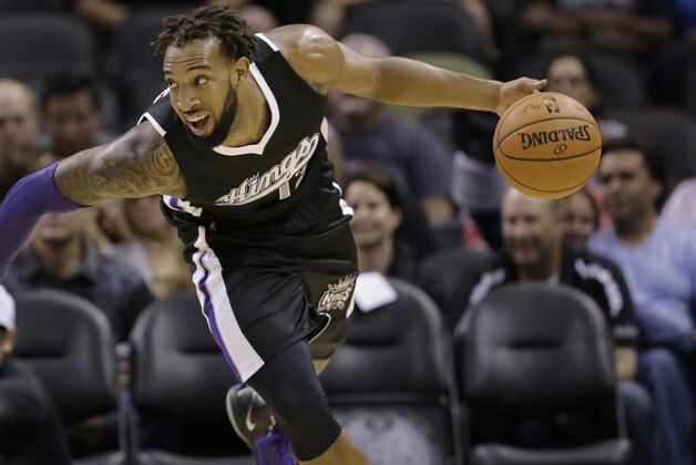 Sacramento Kings' Derrick Williams (13) drives around San Antonio Spurs' JaMychal Green (41) during the first half of an NBA preseason basketball game, Monday, Oct. 20, 2014, in San Antonio. (AP Photo/Eric Gay)