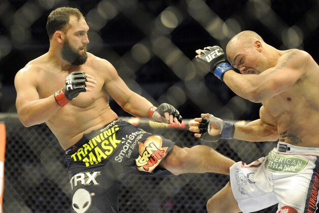 Johny Hendricks, left, lands a kick on  Robbie Lawler during a UFC 171 mixed martial arts welterweight title bout, Saturday, March 15, 2014, in Dallas. Hendricks won by decision. (AP Photo/Matt Strasen)