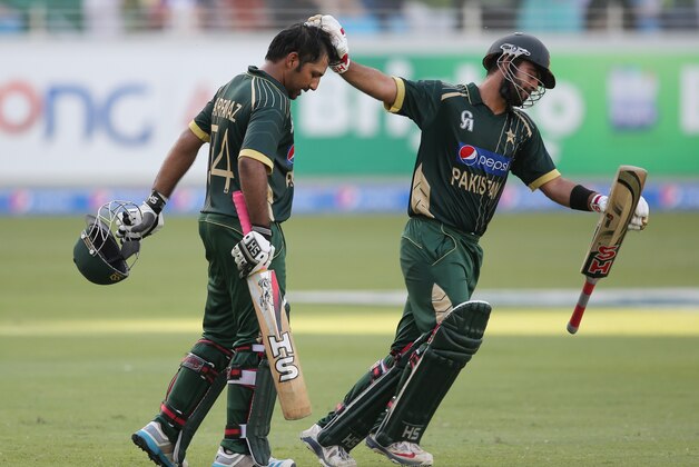 Pakistani batsman Sarfraz Ahmed, left, receives an encouragement from Ahmed Shehzad after he scored half a century during the second one day international match between Australia and Pakistan in Dubai, United Arab Emirates, Friday, Oct. 10, 2014. (AP Photo/Kamran Jebreili)